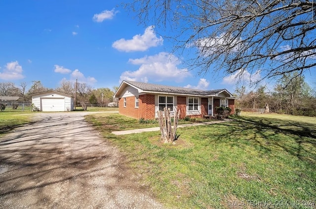 ranch-style home featuring a garage, an outbuilding, and a front yard