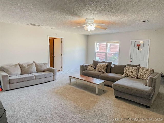 carpeted living room with ceiling fan and a textured ceiling