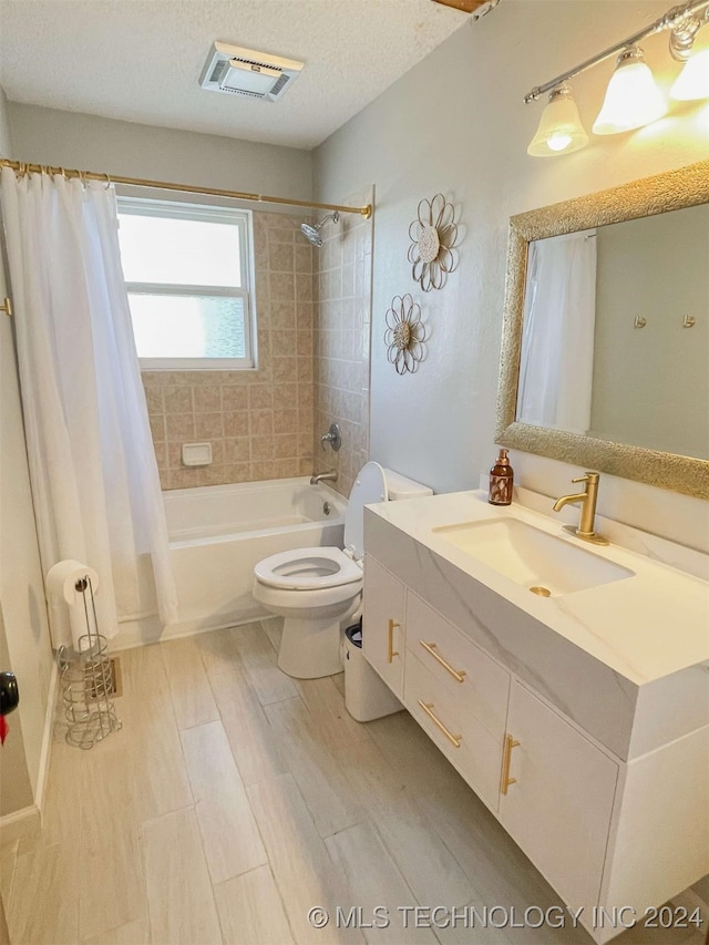 full bathroom with shower / tub combo with curtain, vanity, a textured ceiling, and toilet