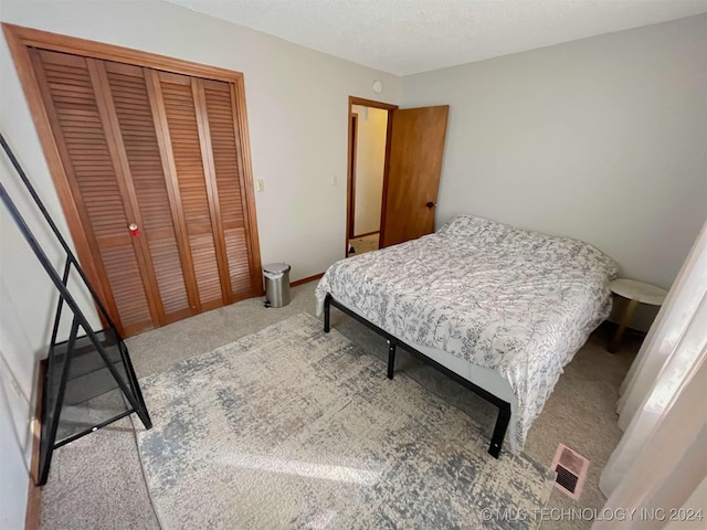 carpeted bedroom featuring a textured ceiling and a closet