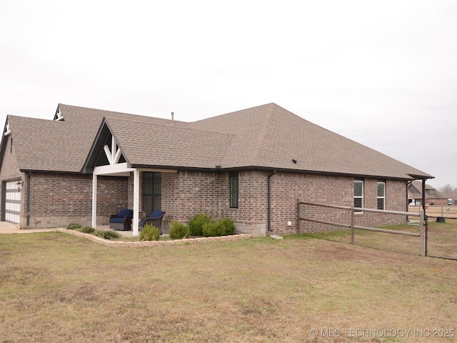 view of side of home with a lawn and a garage