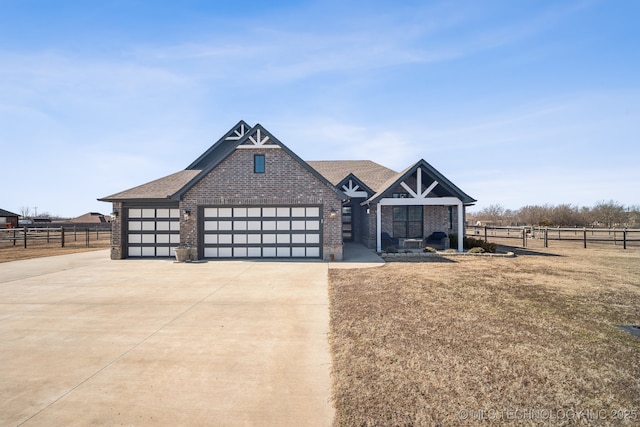 view of front of property featuring a garage and a rural view