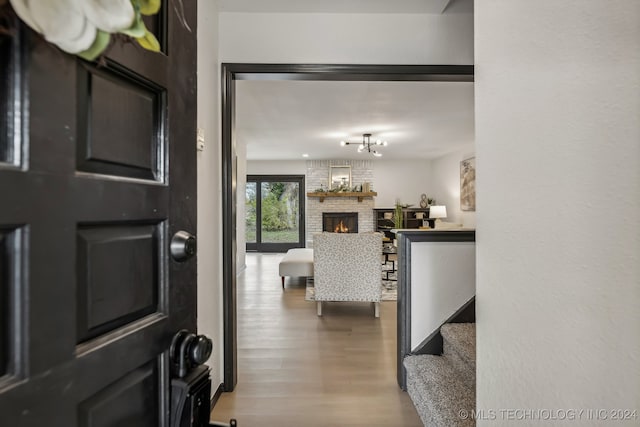 foyer with light hardwood / wood-style flooring and a brick fireplace