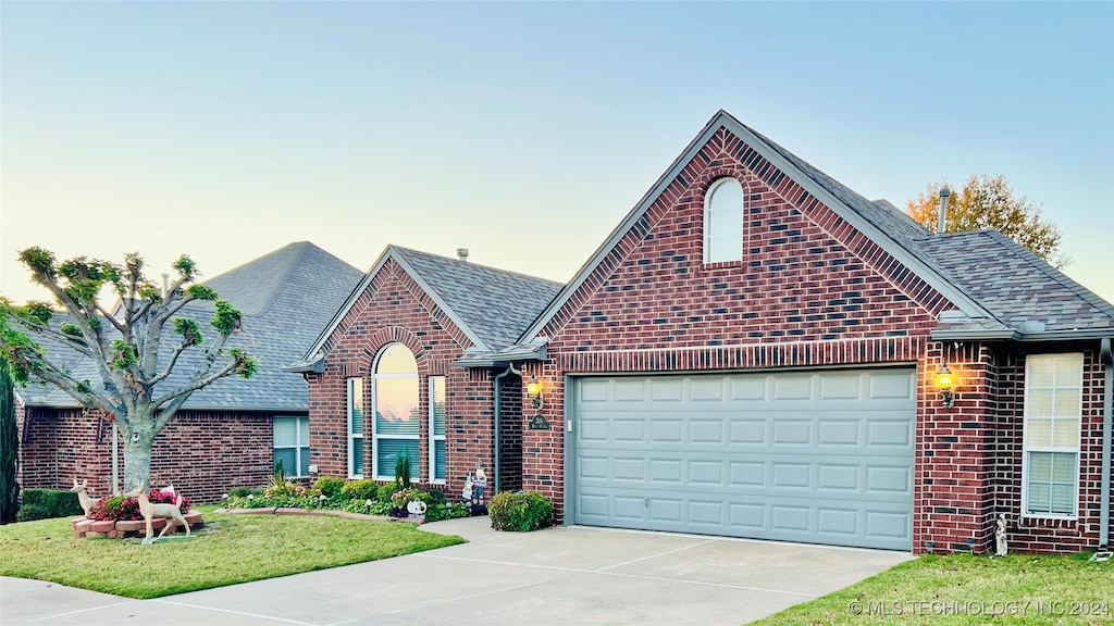 view of front facade with a lawn and a garage