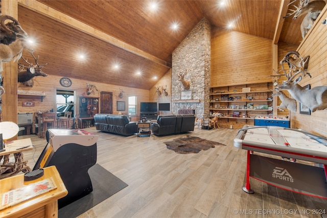 playroom featuring wooden ceiling, high vaulted ceiling, wooden walls, a fireplace, and light wood-type flooring