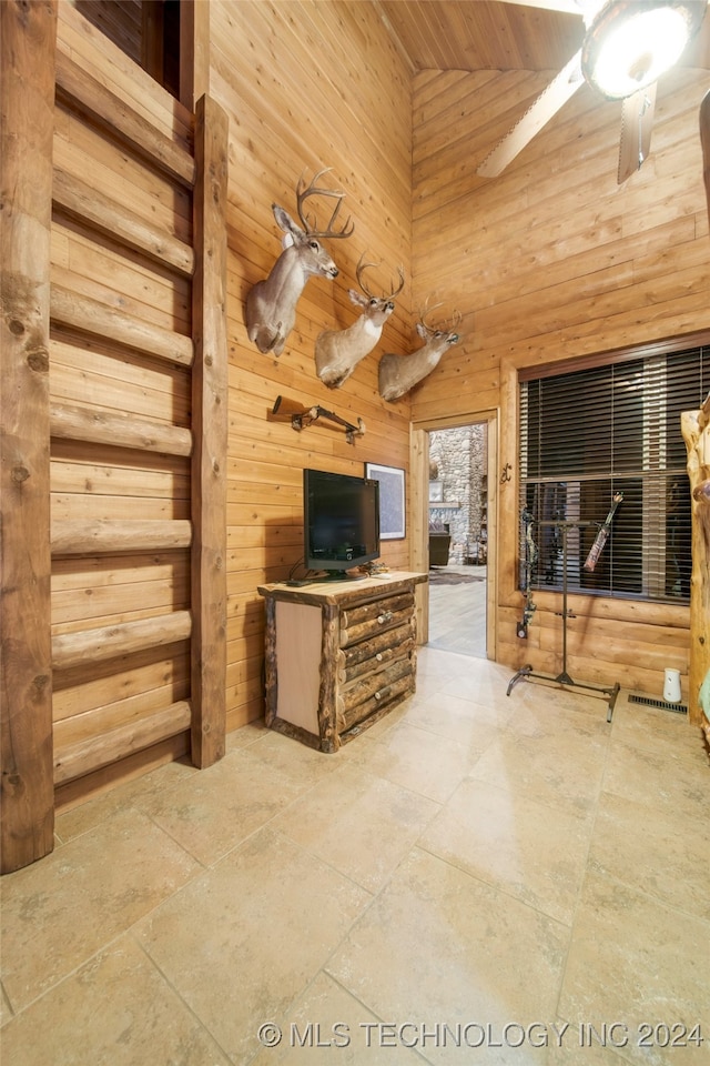 living room with ceiling fan, wooden walls, high vaulted ceiling, and wooden ceiling