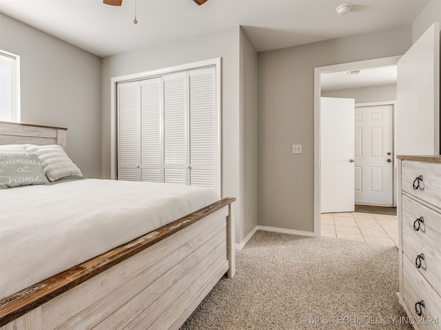 carpeted bedroom featuring ceiling fan and a closet