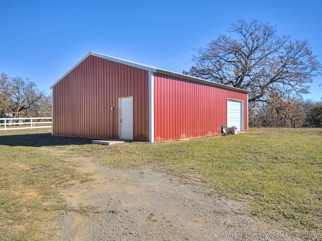 view of outdoor structure with a lawn and a garage