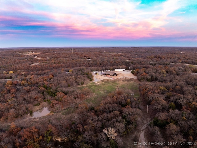 aerial view at dusk featuring a water view