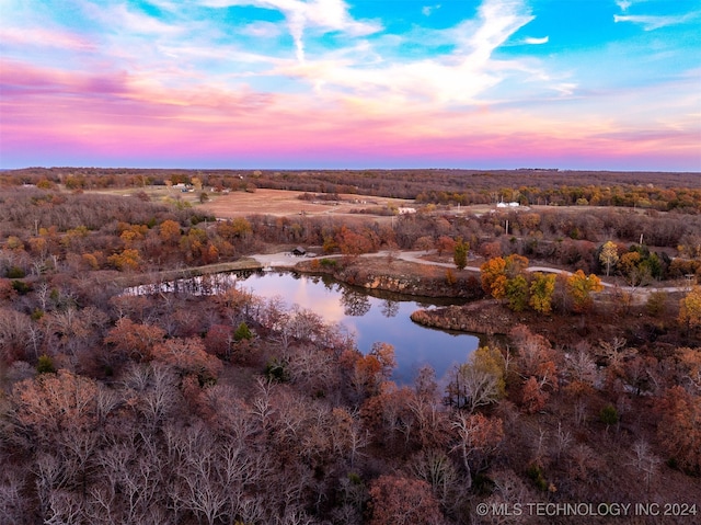 aerial view at dusk featuring a water view