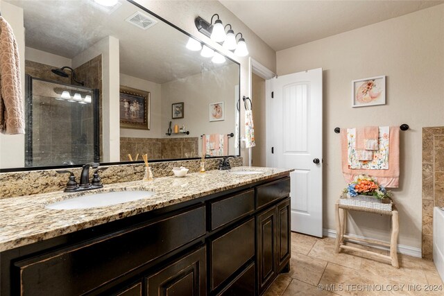 bathroom featuring tile patterned flooring, vanity, and walk in shower