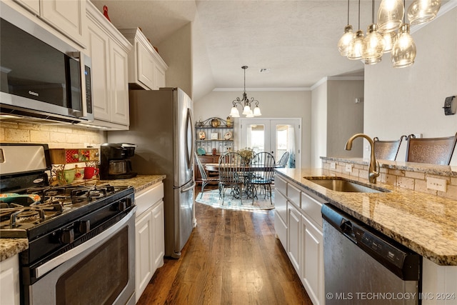 kitchen with pendant lighting, sink, an island with sink, appliances with stainless steel finishes, and white cabinetry