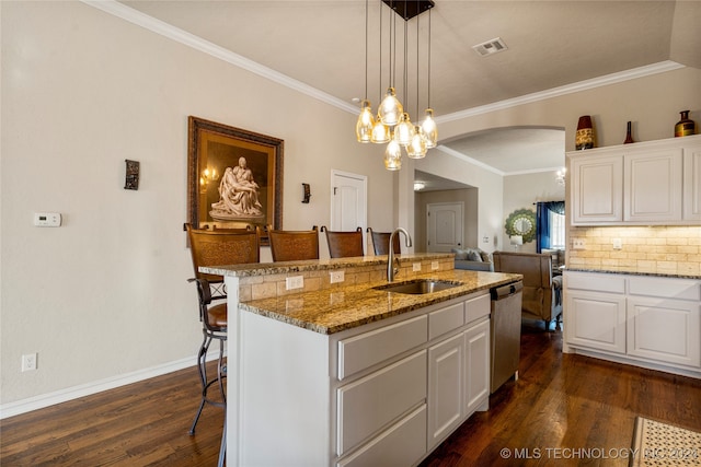 kitchen featuring a center island with sink, sink, dark hardwood / wood-style floors, a kitchen bar, and white cabinetry