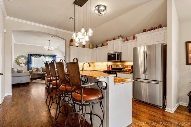 kitchen featuring visible vents, arched walkways, stainless steel appliances, and dark wood finished floors