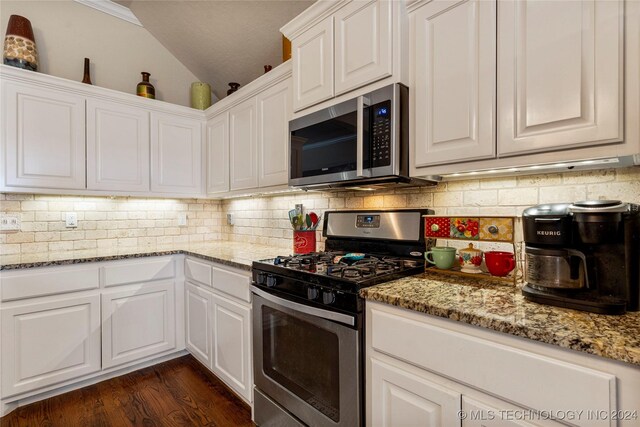 kitchen with decorative backsplash, light stone counters, stainless steel appliances, white cabinets, and dark hardwood / wood-style floors