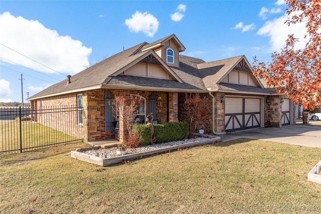 view of front of home with covered porch, a garage, and a front yard