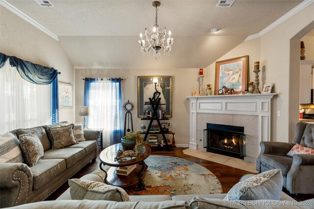 living room with a tile fireplace, a notable chandelier, crown molding, light hardwood / wood-style floors, and lofted ceiling