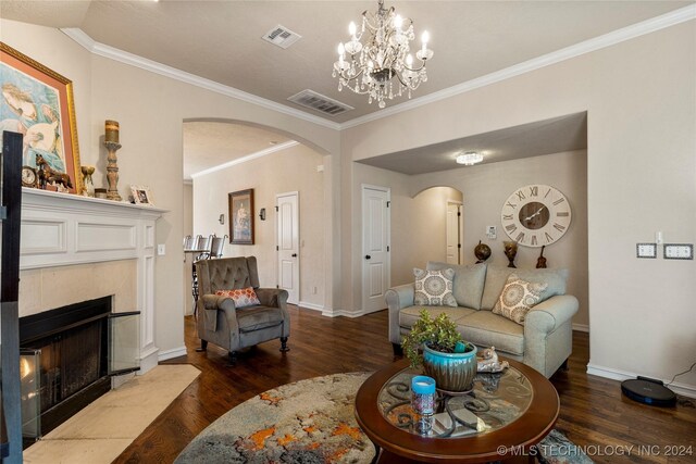 living room featuring a fireplace, hardwood / wood-style floors, a chandelier, and crown molding