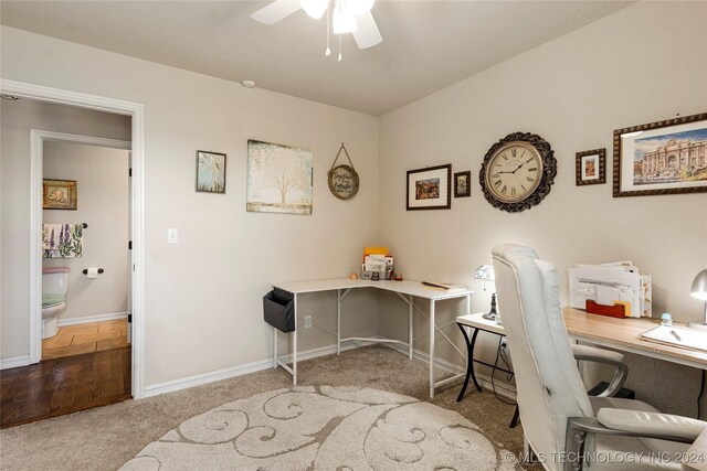 carpeted office space featuring ceiling fan