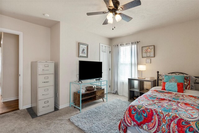 carpeted bedroom with a textured ceiling and ceiling fan