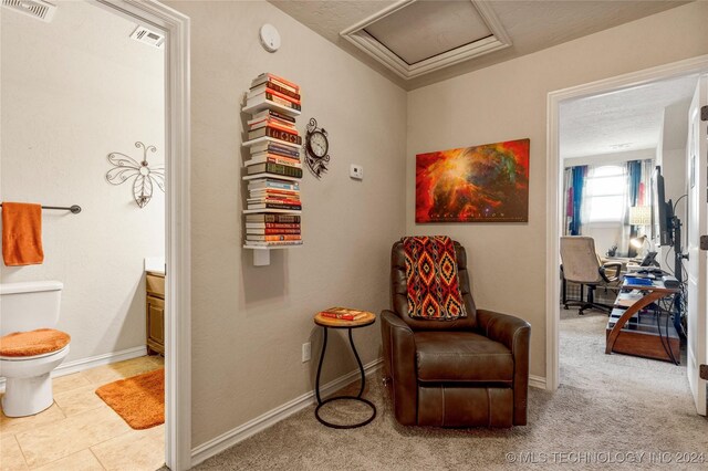 sitting room featuring attic access, visible vents, carpet floors, and baseboards