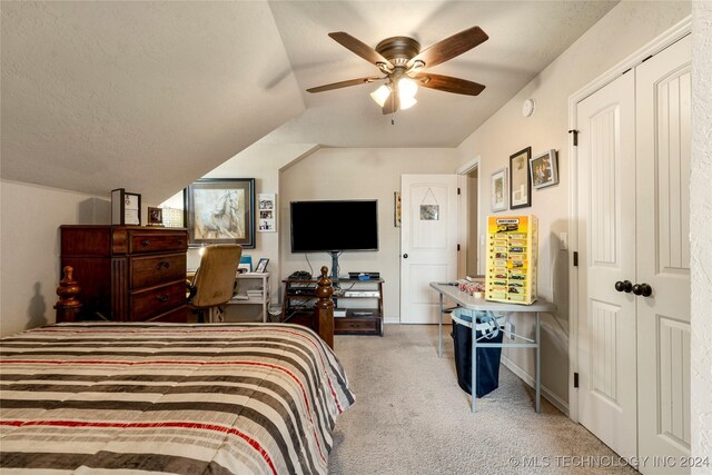 carpeted bedroom with baseboards, a ceiling fan, vaulted ceiling, and a textured ceiling