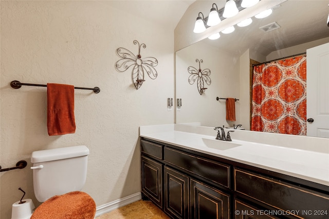 bathroom featuring tile patterned flooring, vanity, lofted ceiling, and toilet