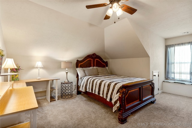 carpeted bedroom with a textured ceiling, vaulted ceiling, and ceiling fan