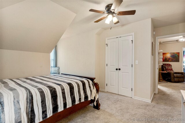 bedroom featuring lofted ceiling, carpet floors, a ceiling fan, baseboards, and a closet