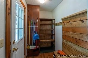 mudroom featuring hardwood / wood-style floors and wooden walls