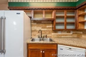 kitchen with decorative backsplash, sink, and white appliances