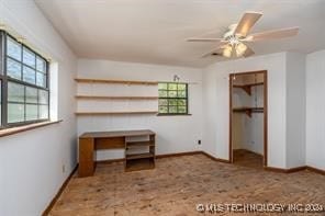 unfurnished bedroom featuring a spacious closet, a closet, and ceiling fan