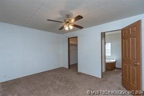 unfurnished bedroom with ceiling fan, ensuite bathroom, light carpet, and a closet