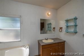 bathroom with a tub to relax in and vanity