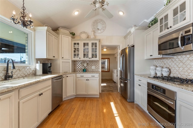 kitchen with decorative light fixtures, appliances with stainless steel finishes, light hardwood / wood-style flooring, and sink