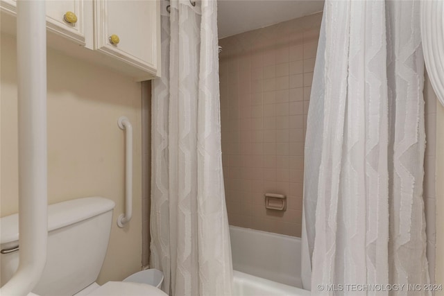 bathroom with toilet and shower / tub combo with curtain