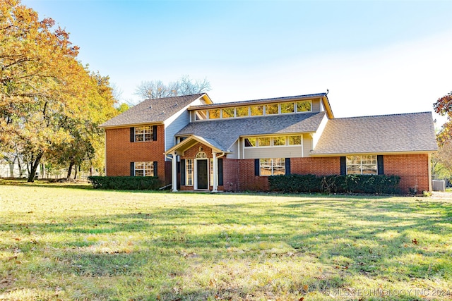 view of front of home with a front lawn and central air condition unit