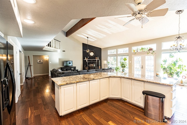 kitchen featuring light stone countertops, stainless steel fridge, a textured ceiling, dark wood-type flooring, and vaulted ceiling with beams