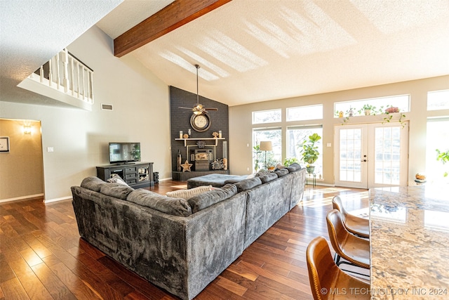 living room featuring french doors, a textured ceiling, a wealth of natural light, and dark wood-type flooring