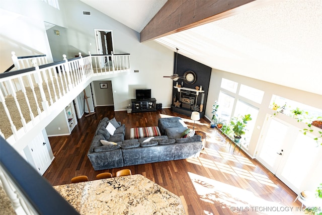 living room featuring a fireplace, dark wood-type flooring, and high vaulted ceiling