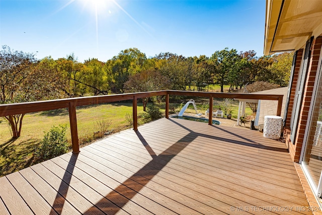 wooden terrace featuring a yard