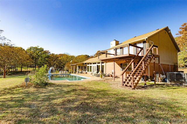 exterior space with a water slide, a patio, and a lawn