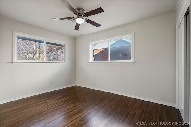 empty room with dark hardwood / wood-style floors, ceiling fan, and crown molding