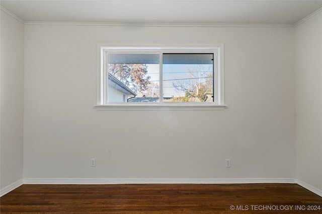 empty room featuring dark hardwood / wood-style floors and ornamental molding