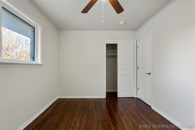 unfurnished bedroom featuring ceiling fan, a closet, dark wood-type flooring, and ornamental molding