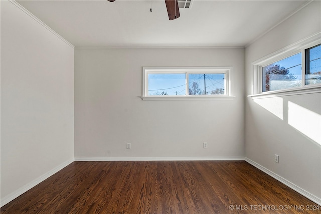 spare room featuring dark wood-type flooring, crown molding, ceiling fan, and a healthy amount of sunlight