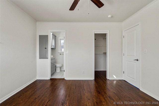 unfurnished bedroom with ceiling fan, dark wood-type flooring, a spacious closet, connected bathroom, and electric panel