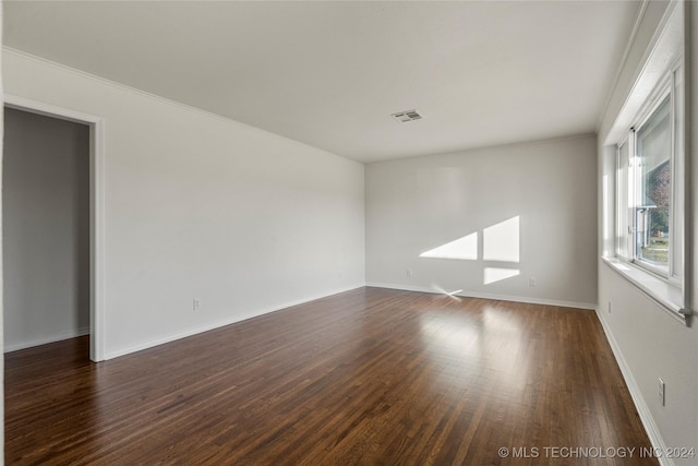 unfurnished room featuring dark hardwood / wood-style flooring and ornamental molding