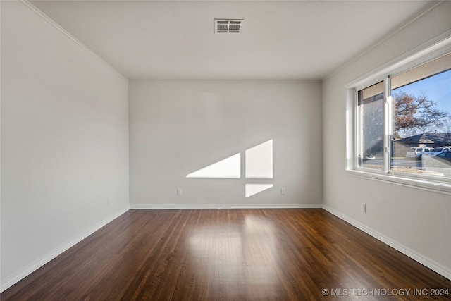 empty room with crown molding and dark hardwood / wood-style floors