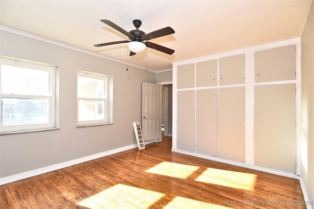 unfurnished bedroom featuring hardwood / wood-style flooring, ceiling fan, and crown molding